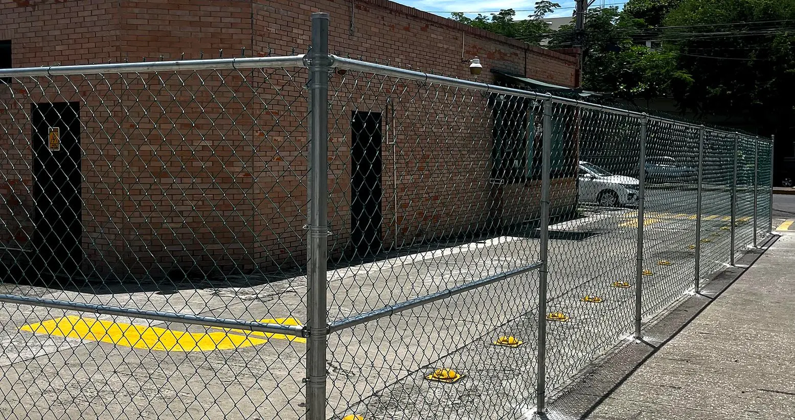 Cerca de malla ciclónica galvanizada nueva alrededor de una bodega, instalada por Cercas y Techos